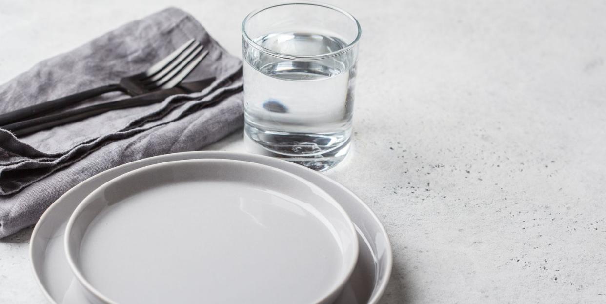 empty plate and glass of water, white background medical fasting concept