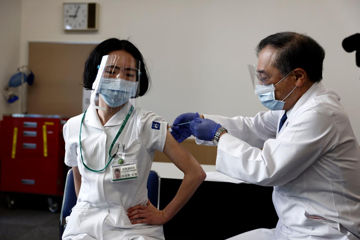 A medical worker receives a dose of the COVID-19 vaccine at Tokyo Medical Center in Tokyo on Wednesday, Feb. 17, 2021.