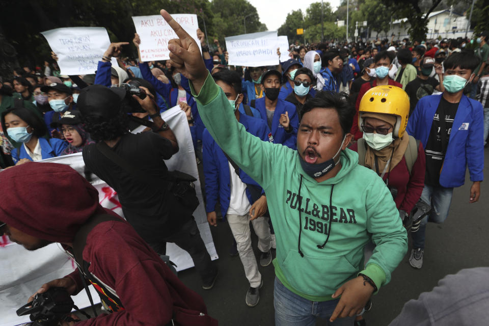 Protesters shout slogans during a rally against the new jobs law in Jakarta, Indonesia,Tuesday, Oct. 20, 2020. Protests against Indonesia's new jobs law were held in cities across the country on Tuesday, with demonstrators calling on the president to revoke the legislation they say will erode labor rights and weaken environmental protections. (AP Photo/Achmad Ibrahim)