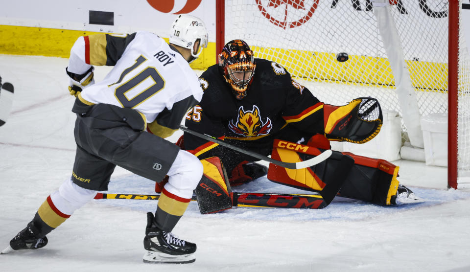 Vegas Golden Knights forward Nicolas Roy, left, scores against Calgary Flames goalie Jacob Markstrom during third-period NHL hockey game action in Calgary, Albera, Thursday, March 23, 2023. (Jeff McIntosh/The Canadian Press via AP)