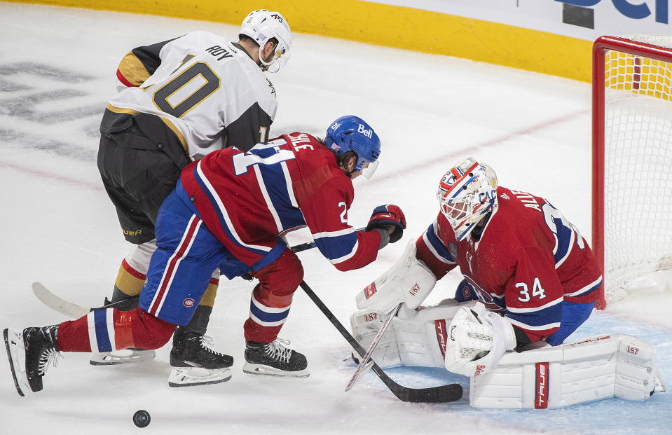 Vegas Golden Knights' Nicolas Roy (10) moves in on Montreal Canadiens goaltender Jake Allen as Canadiens' Kaiden Guhle (21) defends during the first period of an NHL hockey game Saturday, Nov. 5, 2022, in Montreal. (Graham Hughes/The Canadian Press via AP)