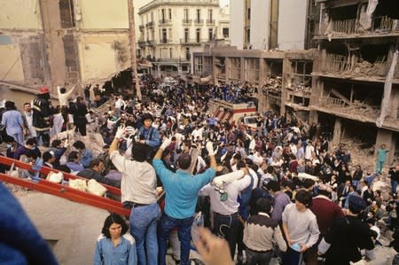 FILE PHOTO: Rescue workers work after an explosives-laden truck blew up outside the Argentine Israeli Mutual Association (AMIA) building on July 18 1994, in Buenos Aires