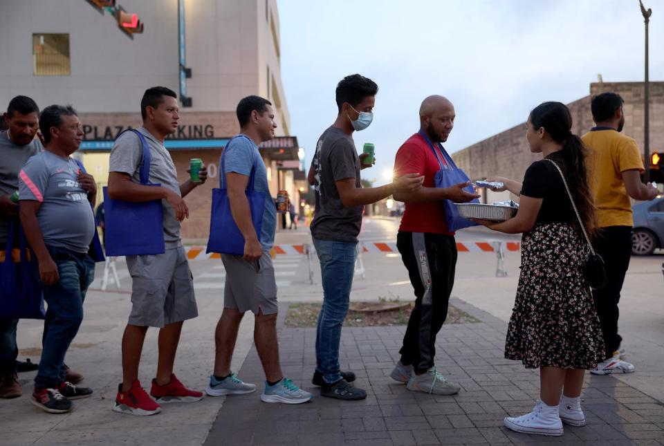 A church member hands out food to migrants on May 10, 2023, in Brownsville, Texas. <a href="https://www.gettyimages.com/detail/news-photo/kimberly-ramierz-from-the-casa-de-oracion-church-hands-out-news-photo/1489006995?adppopup=true" rel="nofollow noopener" target="_blank" data-ylk="slk:Joe Raedle/Getty Images;elm:context_link;itc:0;sec:content-canvas" class="link ">Joe Raedle/Getty Images</a>