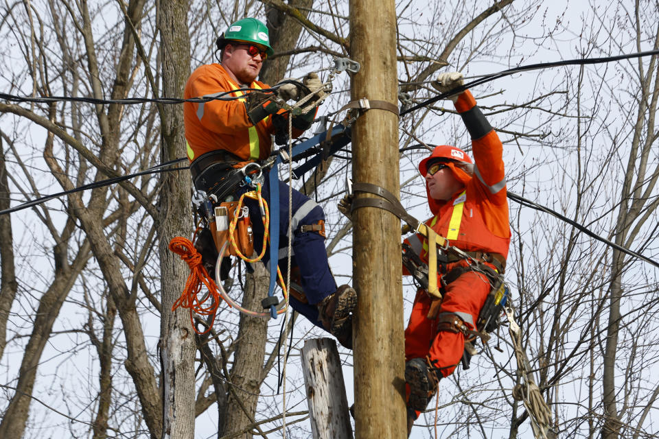 Utility workers repair damaged power lines, Wednesday, Dec. 28, 2022, in Buffalo N.Y., following a winter storm. (AP Photo/Jeffrey T. Barnes)