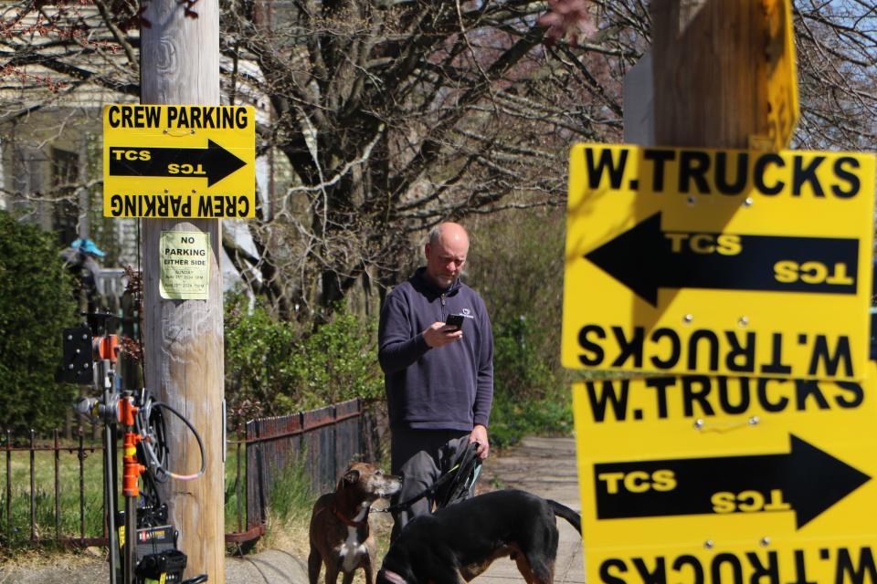 Rick Taylor walks his dogs, Mosi and Zulu, near his Glenwood Avenue home Monday afternoon in Pawtucket while Twentieth Century Studios films "Ella McCay" nearby. [Paul Edward Parker/The Providence Journal]