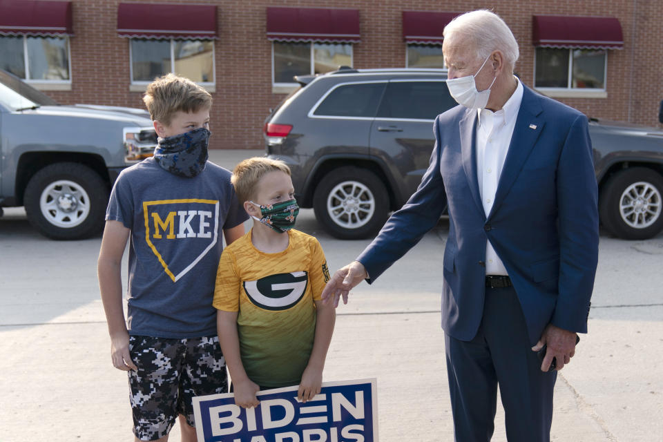 Democratic presidential candidate former Vice President Joe Biden greets children outside of the Wisconsin Aluminum Foundry in Manitowoc, Wis., Monday, Sept. 21, 2020. (AP Photo/Carolyn Kaster)