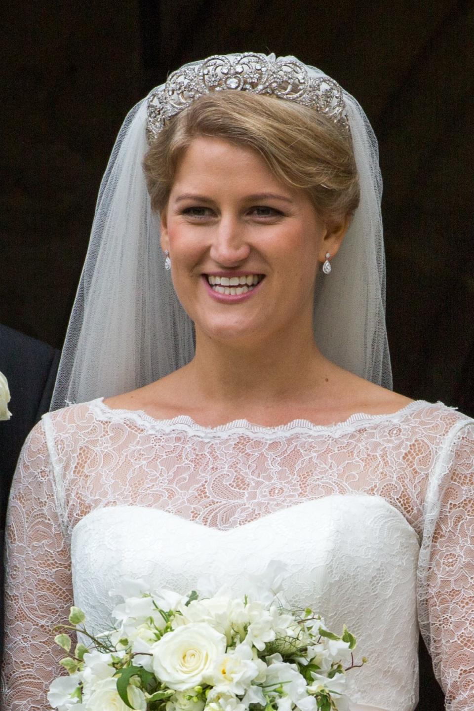 Meghan Markle and Prince Harry arriving for the wedding of Celia McCorquodale in Stoke Rochford, UK.Meghan Markle and Prince Harry were seen smiling and laughing yesterday as they attended his cousin's wedding - with the bride wearing Princess Diana's tiara.The new Duchess of Sussex stunned in a long-sleeved blue-and-white paisley shirt dress and white fascinator at the wedding of Princess Diana's niece, Celia McCorquodale - exactly four weeks after her big day.Celia, who is the younger daughter of the Princess of Wales' sister Lady Sarah McCorquodale, looked beautiful in a lace-bodiced dress and a full veil, held in place by the stunning diamond tiara worn by Princess Diana at her wedding to Prince Charles in 1981.Celia, 29, attended Prince Harry and Meghan's wedding exactly a month ago and she returned the favour by inviting the couple to her country wedding to George Woodhouse at St Andrew and St Mary's Church in Stoke Rochford, Lincolnshire.Harry and Meghan looked delighted to be at the occasion as they arrived at the pretty country church holding hands and smiling and laughing with the other guests.* No UK Papers Or Web ** OK For UK Mags After June 28th *Pictured: Celia McCorquodaleRef: SPL5004400 160618 NON-EXCLUSIVEPicture by: Geoff Robinson Photography / SplashNews.comSplash News and PicturesLos Angeles: 310-821-2666New York: 212-619-2666London: 0207 644 7656Milan: +39 02 4399 8577photodesk@splashnews.comWorld Rights, No United Kingdom Rights