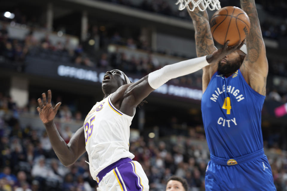 Los Angeles Lakers forward Wenyen Gabriel, left, drives to the rim for a basket as Denver Nuggets center DeMarcus Cousins defends in the first half of an basketball game Sunday, April 10, 2022, in Denver. (AP Photo/David Zalubowski)