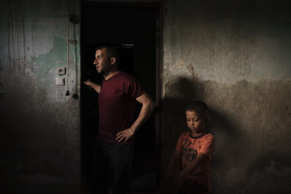 Jalal Nassir stands with his son in their home, damaged in the recent 11-day war between Israel and Hamas, the militant group that controls Gaza, in Beit Hanoun, northern Gaza Strip, Saturday, June 12, 2021. Four wars since 2008 have done about $5 billion in damage to Gaza’s buildings, roads, electrical and water systems, close to double the Strip’s annual economic output. Nearly 250,000 homes have been damaged or destroyed. (AP Photo/Felipe Dana)