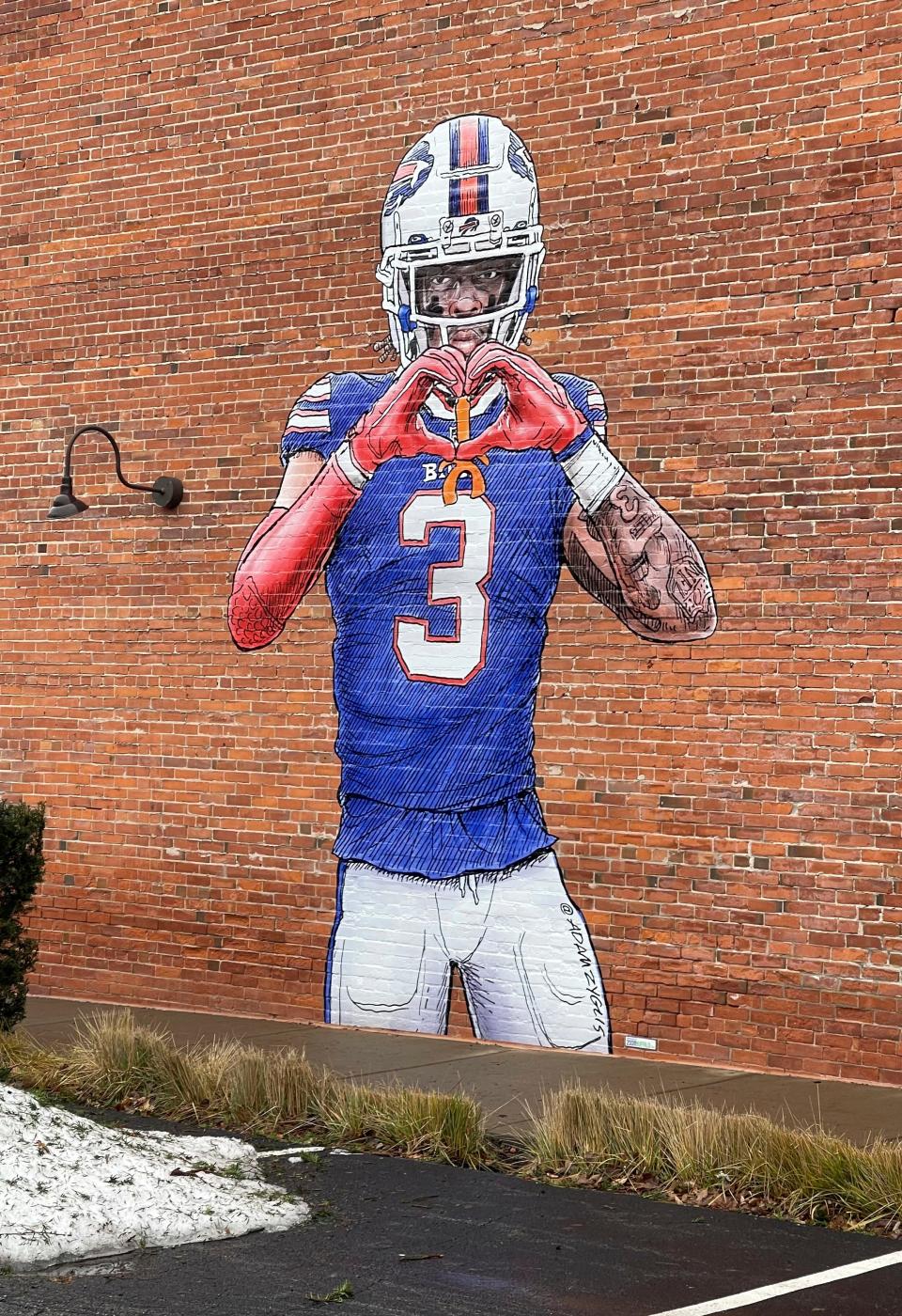 A mural by artist Adam Zyglis of Buffalo Bills player Damar Hamlin, who is recovering after going into cardiac arrest during a game Jan. 2, covers the outside of a building in Buffalo, N.Y., on Wednesday, Jan. 18, 2023. (AP Photo/Carolyn Thompson)