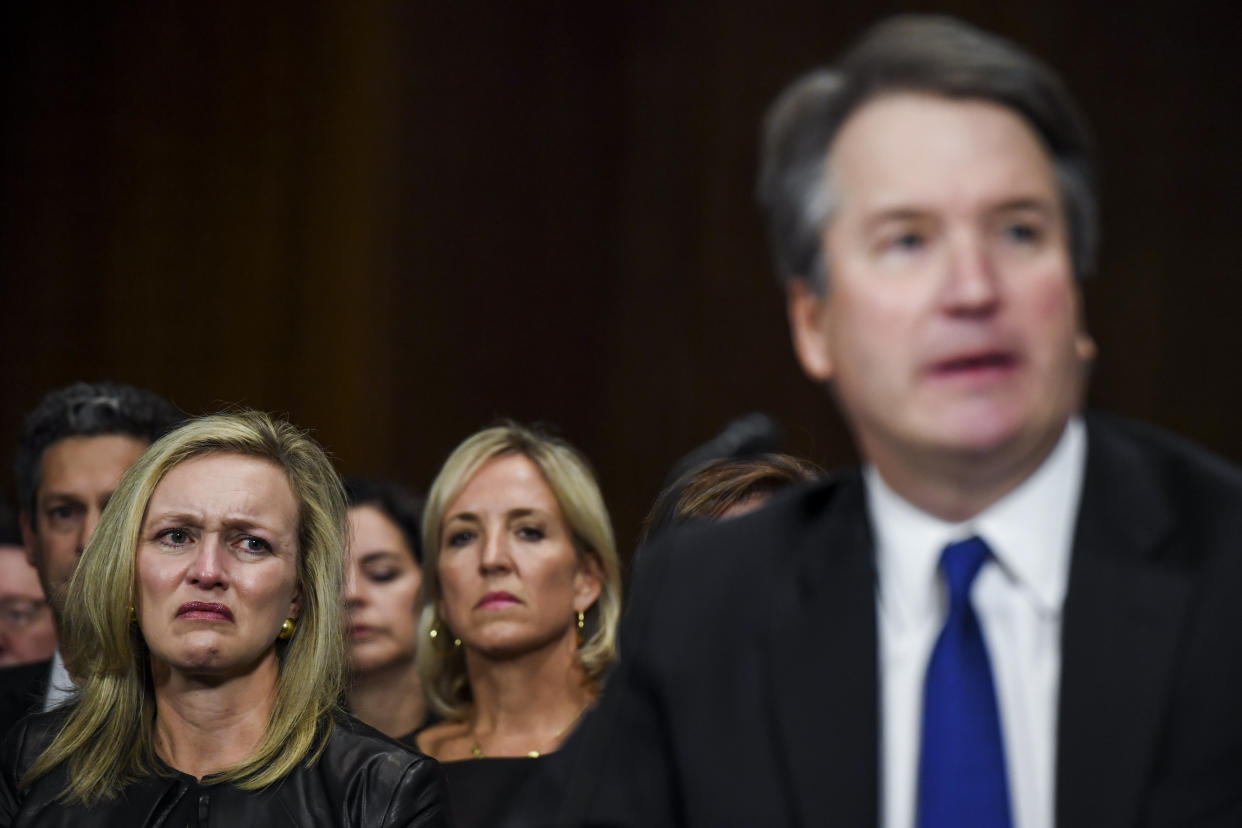 Family friend Laura Cox Kaplan, left, tears up while seated behind Brett Kavanaugh during Thursday's testimony before the Senate Judiciary Committee. (Matt McClain-Pool/Getty Images)