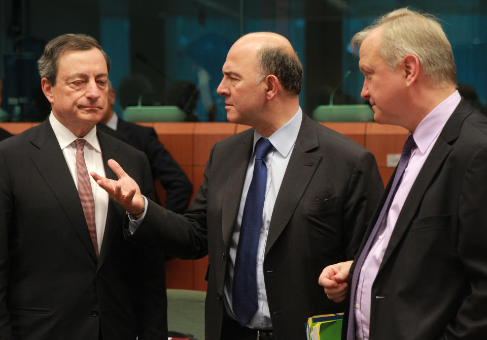 President of the European Central Bank Mario Draghi, left, listens at French Finance Minister Pierre Moscovici, second left, and European Commissioner for Economic and Monetary Affairs Olli Rehn, right, during the eurogroup ministerial meeting at the European Council building in Brussels, Monday March 10, 2014. (AP Photo/Yves Logghe)