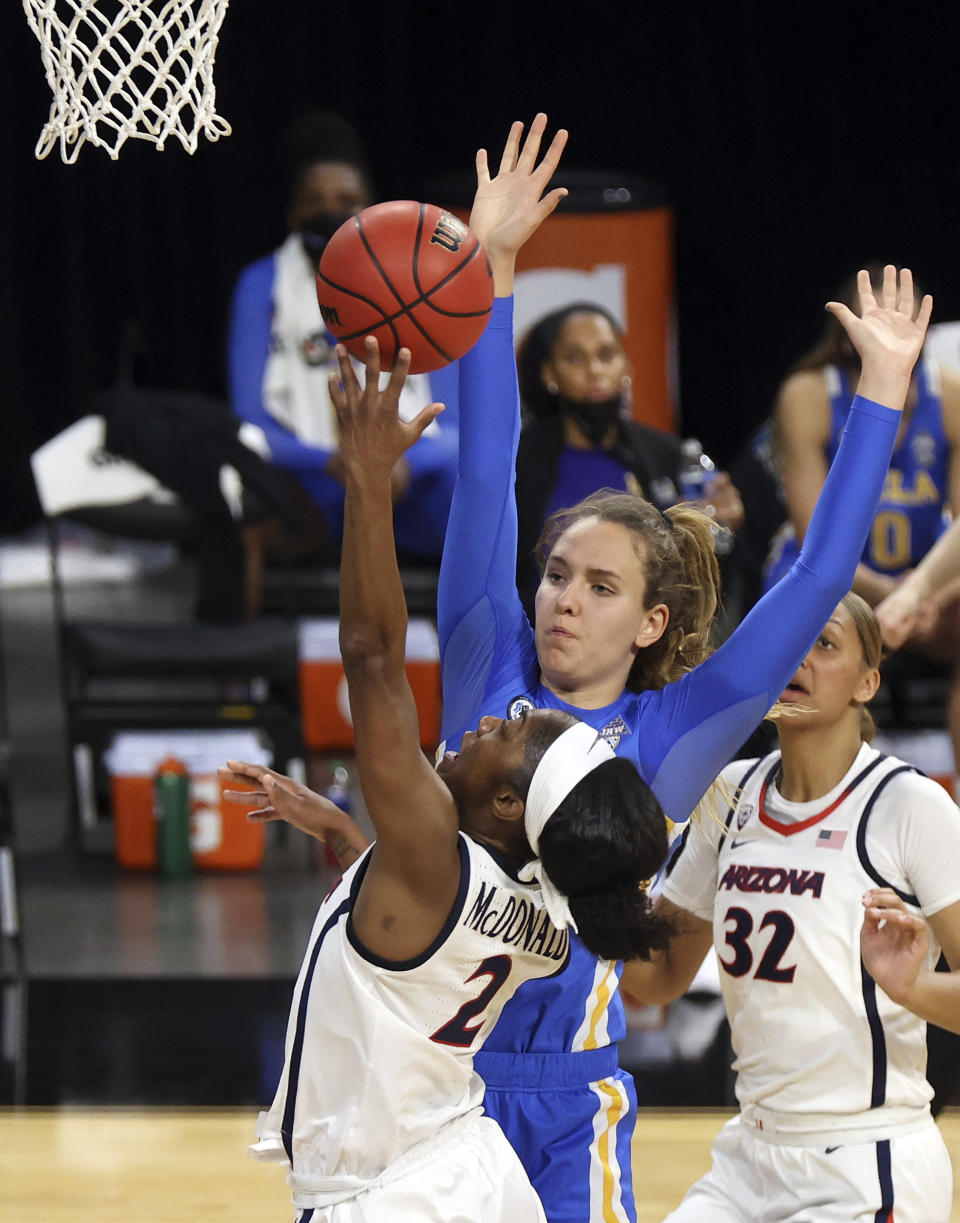 Arizona guard Aari McDonald (2) shoots as UCLA forward Emily Bessoir defends during the first half of an NCAA college basketball game in the semifinals of the Pac-12 women's tournament Friday, March 5, 2021, in Las Vegas. (AP Photo/Isaac Brekken)