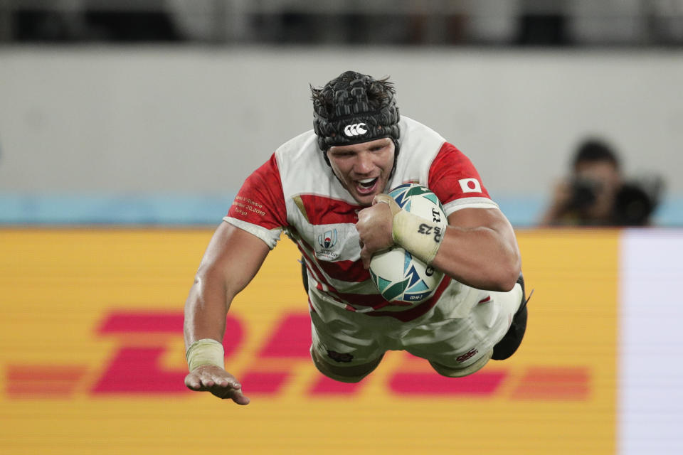 Japan's Pieter Labuschagne is airborne as he scores a try against Russia during the Rugby World Cup Pool A game at Tokyo Stadium in Tokyo, Friday, Sept. 20, 2019. (AP Photo/Jae Hong)