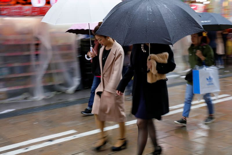 Shoppers walk through the rain in an Osaka shopping district
