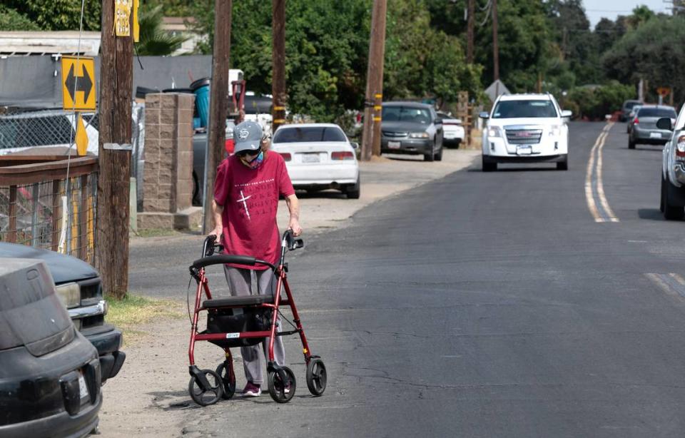 Debbie Smith moves off the street to avoid oncoming cars, she says “she shakes’ when she needs to walk around parked cars that jut out to the edge of River Road leaving no room for her to pass safely as moving vehicles pass by. Traffic planners held a pop-up meeting to gain input from residents to help refine street design concepts in the Bystrom area of unincorporated south Modesto, Calif., on Friday, August 5, 2022.