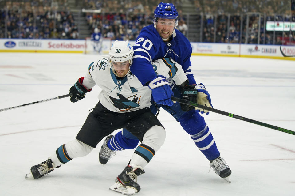 San Jose Sharks defenseman Mario Ferraro (38) and Toronto Maple Leafs forward Nick Ritchie (20) jostle while going to the puck during the second period of an NHL hockey game Friday, Oct. 22, 2021, in Toronto. (Evan Buhler/The Canadian Press via AP)