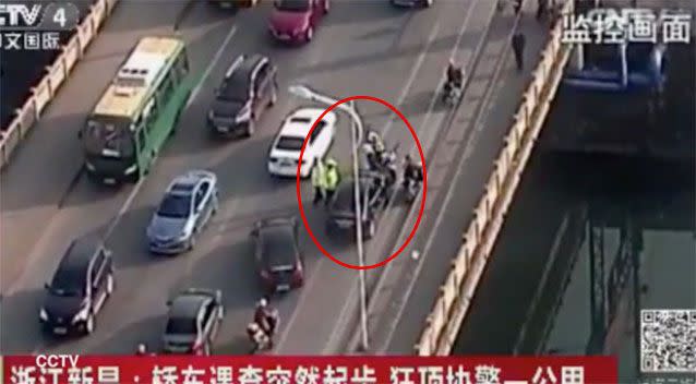 Footage shows traffic officers surrounding a motorist while trying to give the driver a ticket. Picture CCTV 4, China