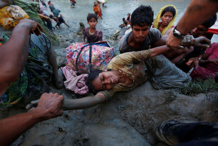 Photographers help a Rohingya refugee woman to come out of Naf river as Rohingya refugees cross the Bangladesh-Myanmar border in Palong Khali, near Cox’s Bazar, Bangladesh November 1, 2017. REUTERS/Adnan Abidi