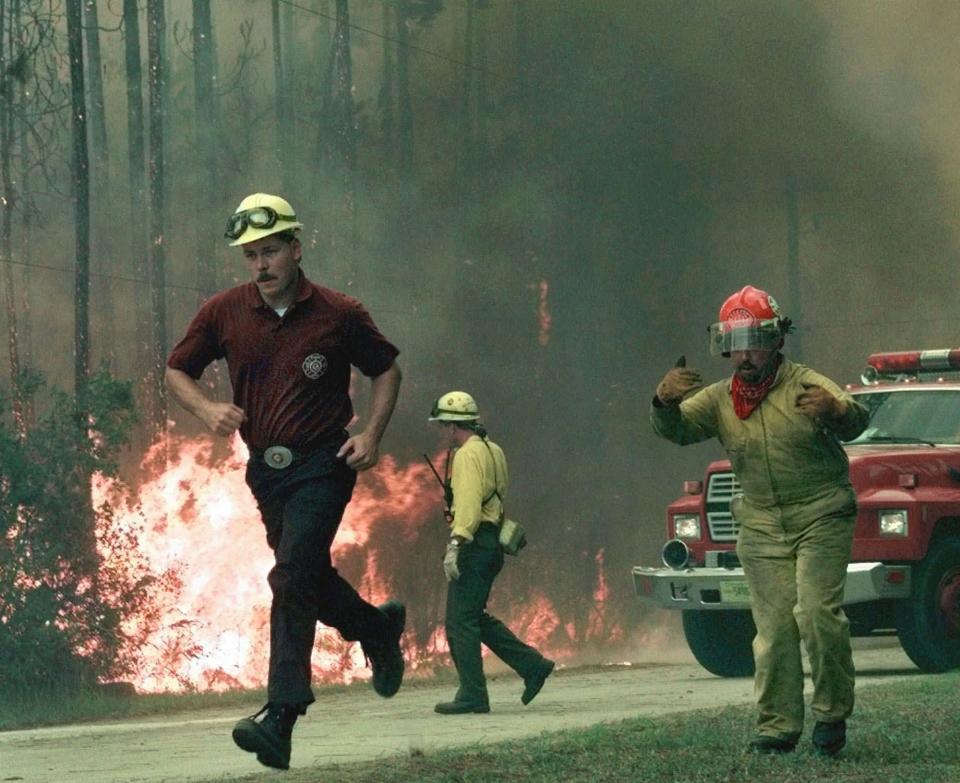 Firefighters call for more equipment as a firestorm, whipped by strong winds, moved toward several homes in the Rima Ridge area northwest of Ormond Beach on July 2, 1998.