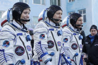 U.S. astronaut Anne McClain, left, Russian cosmonaut Оleg Kononenko‎, centre, and CSA astronaut David Saint Jacques, members of the main crew of the expedition to the International Space Station (ISS), report to members of the State Committee prior to the launch of Soyuz MS-11 space ship at the Russian leased Baikonur cosmodrome, Kazakhstan, Monday, Dec. 3, 2018. (AP Photo/Dmitri Lovetsky, Pool)