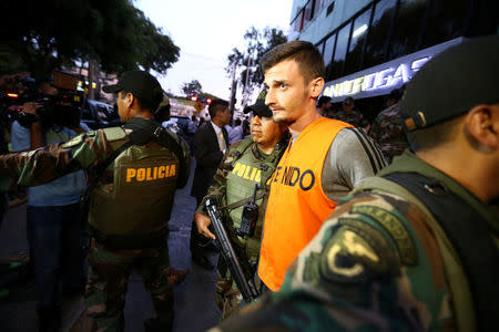 Peruvian police escort detainees after seized more than two tonnes of cocaine hidden in packages of asparagus destined for Amsterdam at police headquarters in Lima, Peru, January 12, 2017. REUTERS/Mariana Bazo