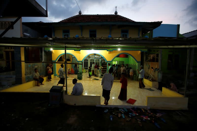 Muslims gather at a mosque as they prepare for prayers during sunset at Tambaklorok, a village affected by land subsidence and rising sea level, in Semarang