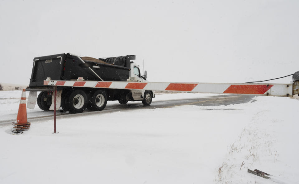 An Elbert County truck with sand passes the closure barrier on Colorado County Highway 86 just east of Kiowa, Colo.. The road was closed to Limon after a blizzard hit the eastern plains of the state. Jerilee Bennett/The Gazette via AP)