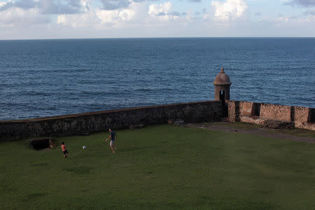 A boy and a man play football near the San Cristobal castle after Puerto Rico Governor Ricardo Rossello declared a state of emergency in preparation for Hurricane Irma, in Old San Juan, Puerto Rico September 4, 2017. REUTERS/Alvin Baez