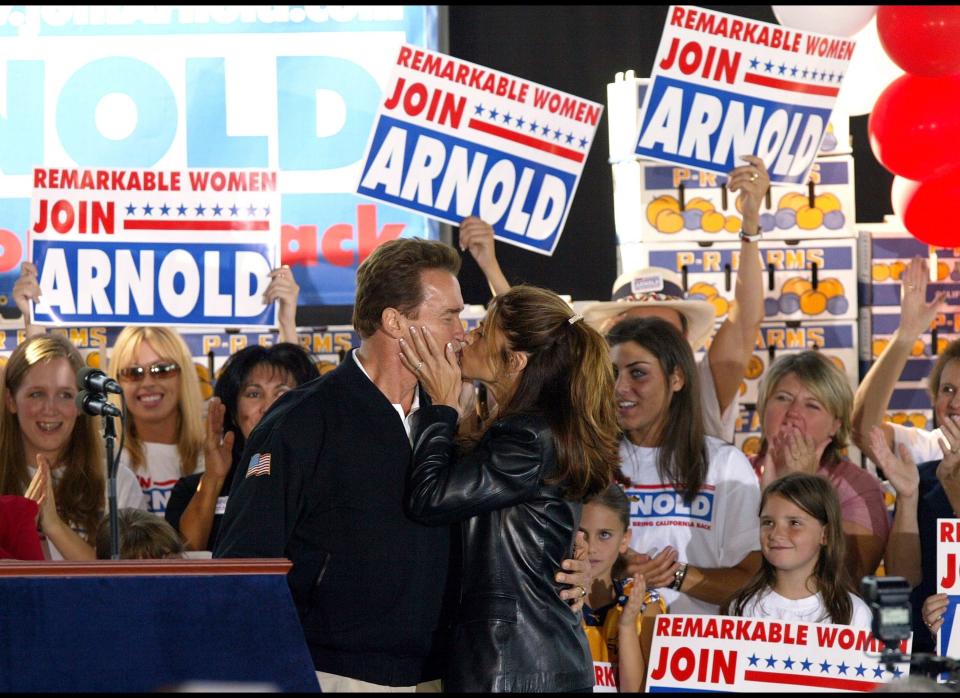 Republican gubernatorial candidate Arnold Schwarzenegger kisses his wife Maria Shriver during a rally at P-R Farms October 4, 2003 in Clovis, California. Schwarzenegger continues on his four-day bus tour through California that began in San Diego and ends in Sacramento. There are six buses in the tour, all named after Schwarzenegger films. (Photo by Justin Sullivan/Getty Images/October 4, 2003) 