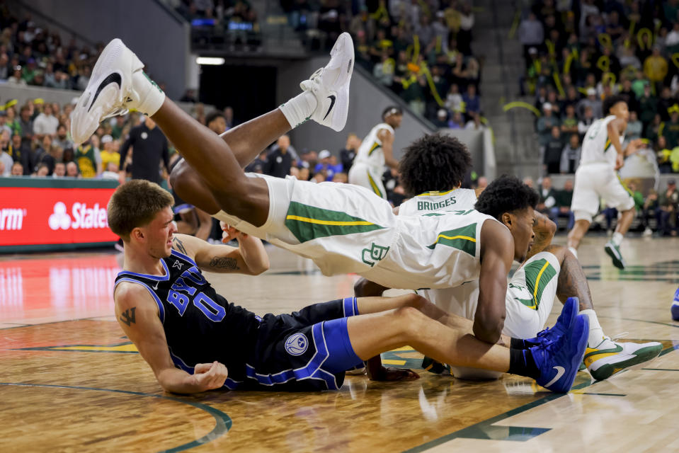 Baylor center Yves Missi, top, is brought down by BYU forward Noah Waterman, left, during the second half of an NCAA college basketball game Tuesday, Jan. 9, 2024, in Waco, Texas. Baylor won 81-72. (AP Photo/Gareth Patterson)