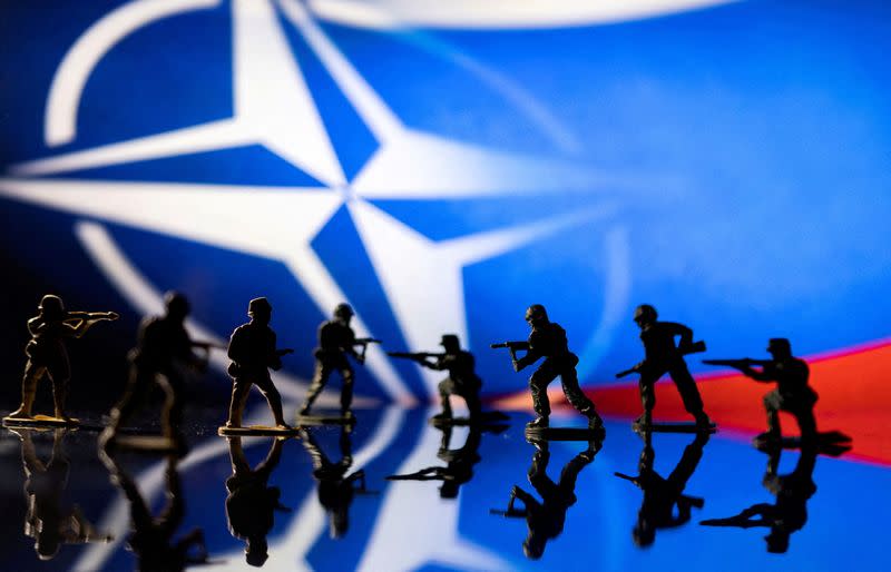 FILE PHOTO: Illustration shows army figurines on NATO logo and Russian flag colours background
