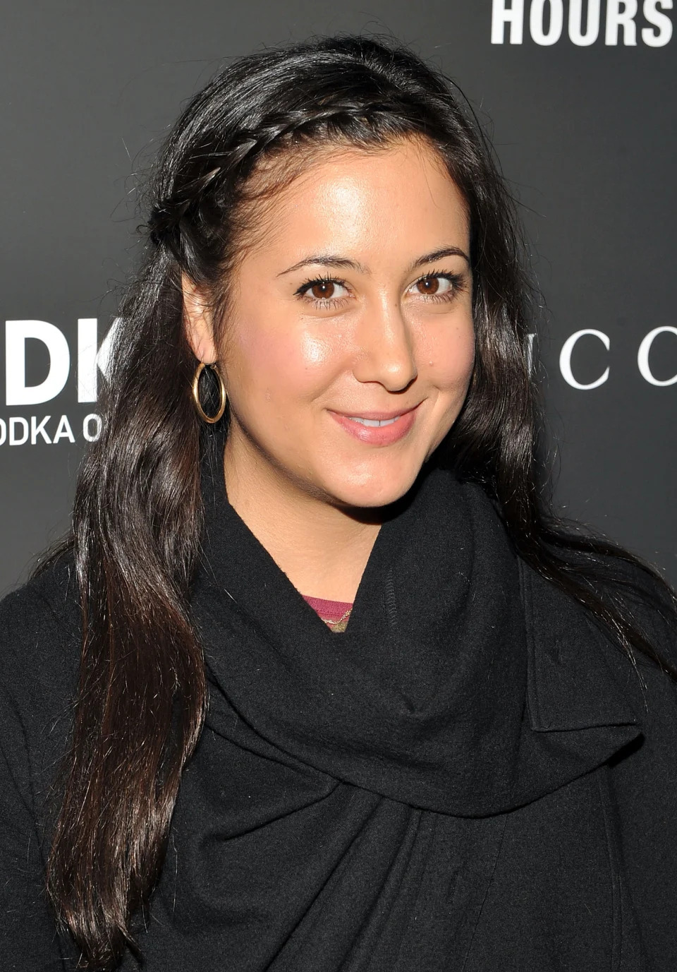 Sorry, I don't know who this is. A woman with long brown hair and braid, smiling while posing in front of a backdrop at an event