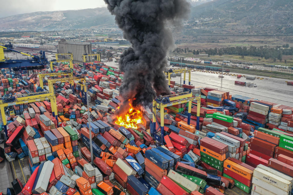 A fire amid overturned shipping containers in a shipping yard in Hatay, Turkey