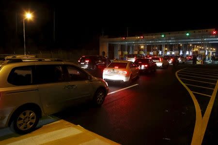 South Korean vehicles transporting employees working at the Kaesong Industrial Complex (KIC) wait to pass the gateway at the South's CIQ (Customs, Immigration and Quarantine), just south of the demilitarised zone separating the two Koreas, in Paju, South Korea, February 11, 2016. REUTERS/Lim Byong-sik/Yonhap