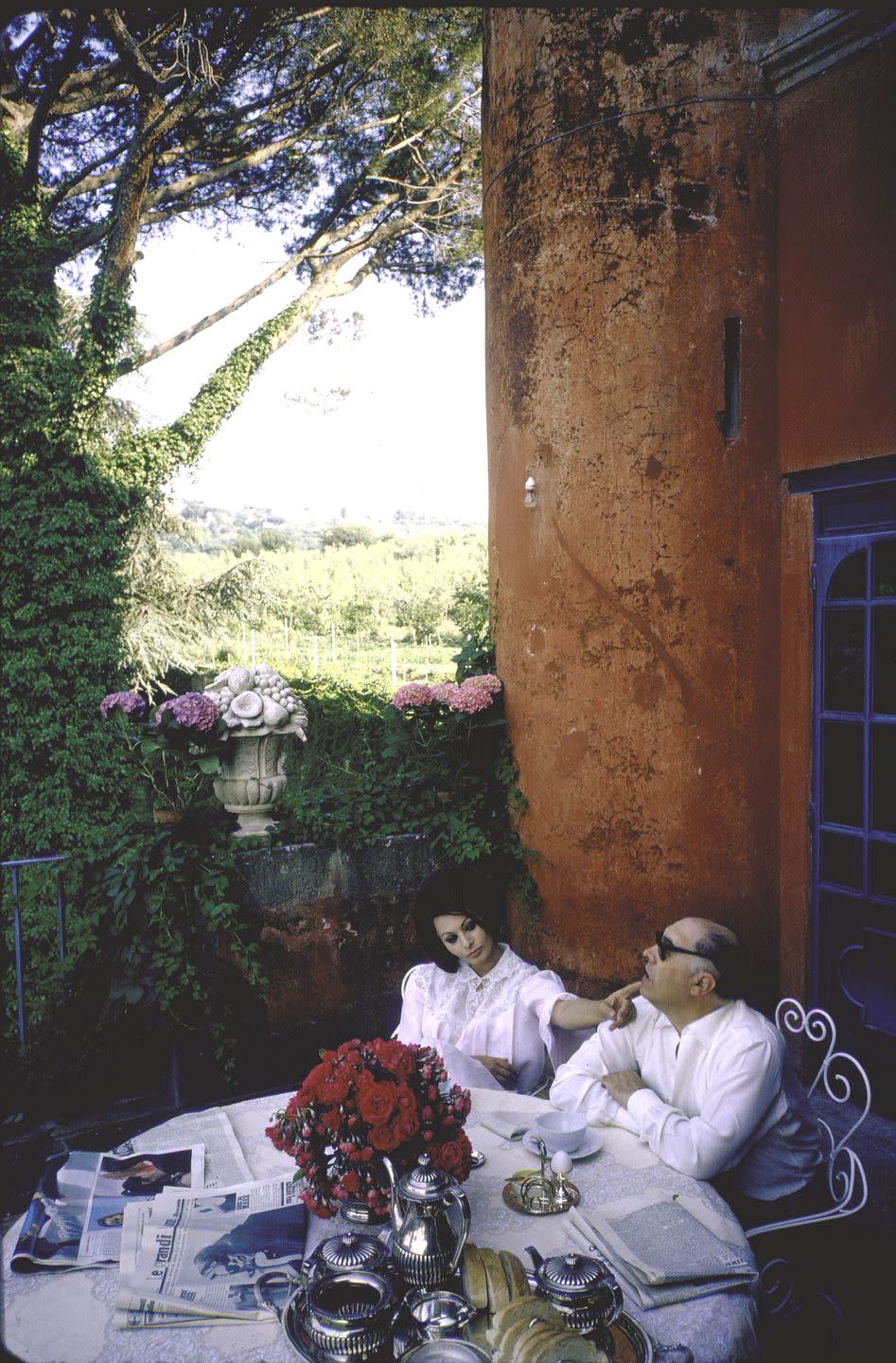<p>Complete with coffee and the morning newspaper, the Italian film star enjoys a leisurely morning on the terrace of her Roman villa with her director husband, Carlo Ponti. </p>