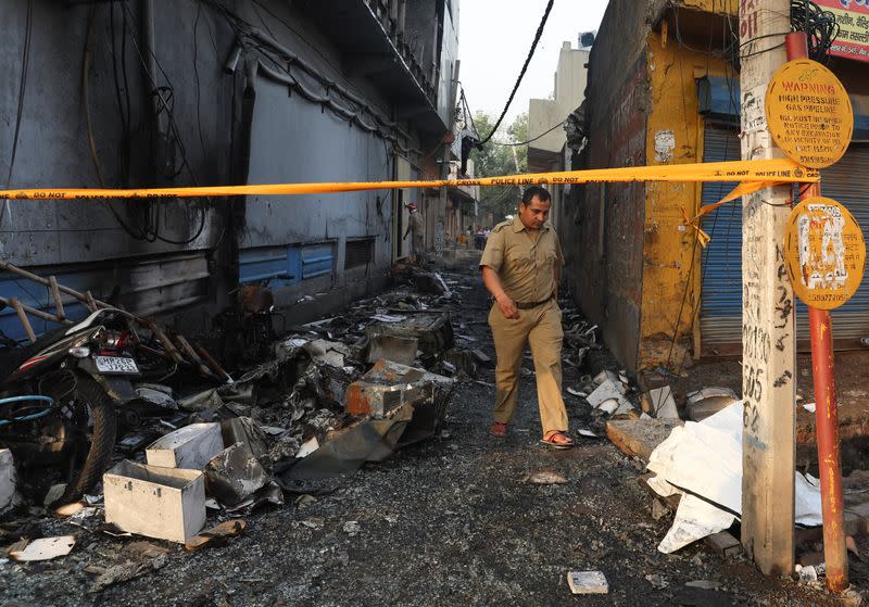 Police official walks at the site of a commercial building that caught fire in New Delhi
