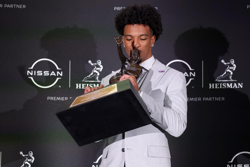 LSU quarterback Jayden Daniels kisses the Heisman Trophy.