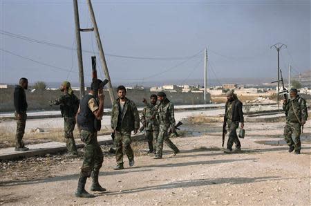 Forces loyal to Syria's President Bashar al-Assad carry their weapons as they gather in the town of Safira November 1, 2013. REUTERS/George Ourfalian