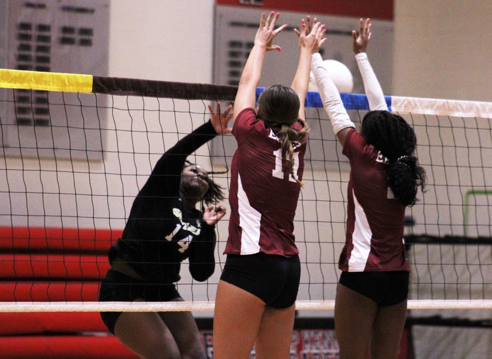 Oakleaf's Tamia Fripp (14) spikes the ball as Episcopal's Kathryn Almond (17) and Chloe Selmer (2) go for the block during Saturday's preseason volleyball match at Bishop Kenny.