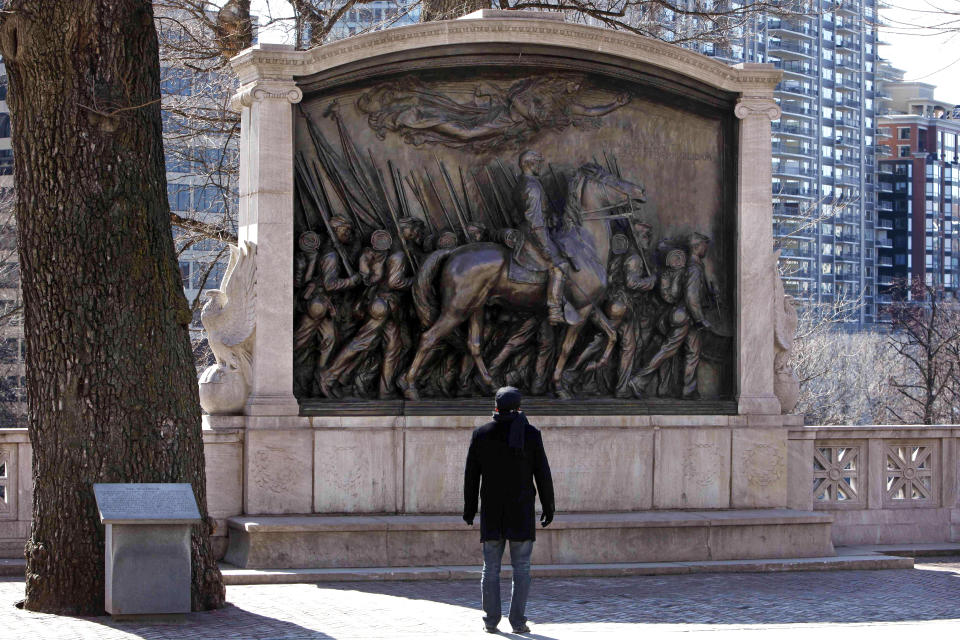 FILE - In this March 26, 2011, file photo, a man stops to admire the memorial to Union Col. Robert Gould Shaw and the 54th Massachusetts Volunteer Infantry Regiment, near the Statehouse in Boston. The monument in downtown Boston honoring a famed Civil War unit of Black soldiers is being fully unveiled to the public Friday, May 28 following a $3 million restoration. (AP Photo/Michael Dwyer, File)