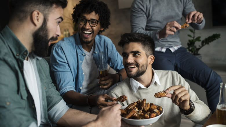 Friends eating chicken wings