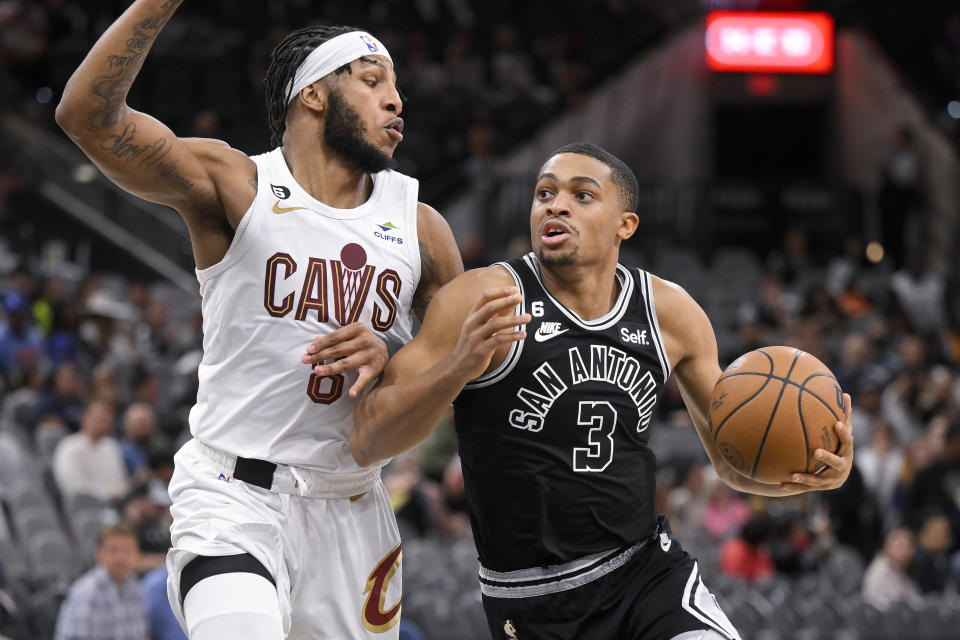 San Antonio Spurs' Keldon Johnson (3) drives against Cleveland Cavaliers' Lamar Stevens during the second half of an NBA basketball game, Monday, Dec. 12, 2022, in San Antonio. San Antonio won 112-111. (AP Photo/Darren Abate)