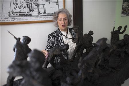 Jewish Holocaust survivor Irena Wodzislawski stands behind statues displayed in a museum commemorating the six million victims of the Nazi genocide, inside her home in the West Bank Jewish settlement of Ariel January 23, 2014. REUTERS/Ronen Zvulun