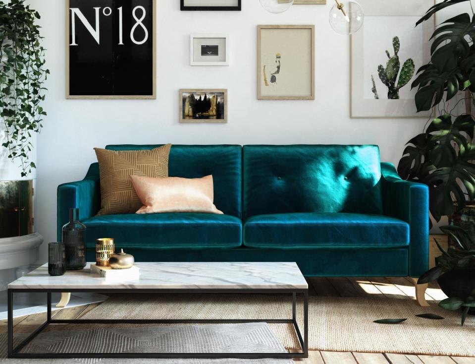 The green velvet couch with sloped arms in a living room