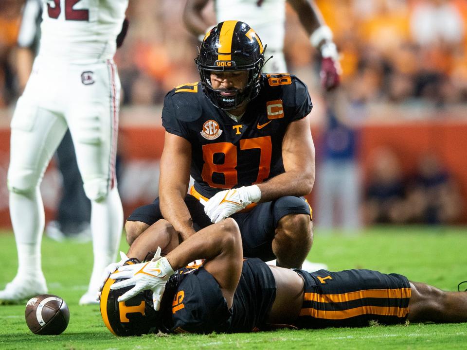 Tennessee tight end Jacob Warren (87) kneels beside Bru McCoy (15) as he lays injured on the field during a football game between Tennessee and South Carolina at Neyland Stadium in Knoxville, Tenn., on Saturday, Sept. 30, 2023.