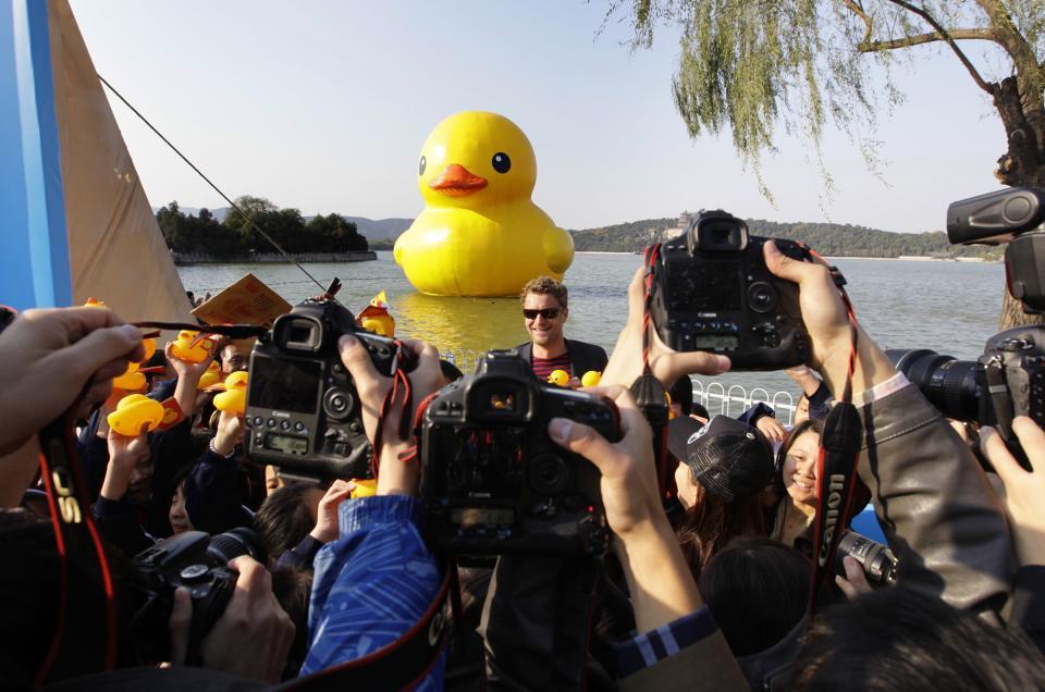 Photographers take pictures of Dutch conceptual artist Hofman in front of his work Rubber Duck in Beijing