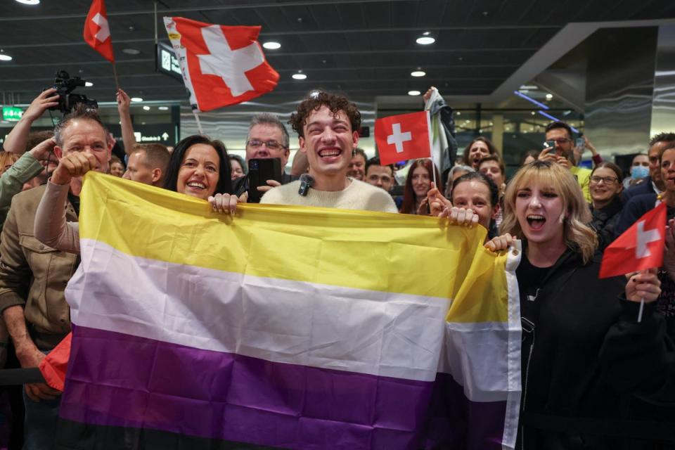 Nemo holding the non-binary flag with supporters at Zurich airport following their Eurovision win (AFP via Getty Images)