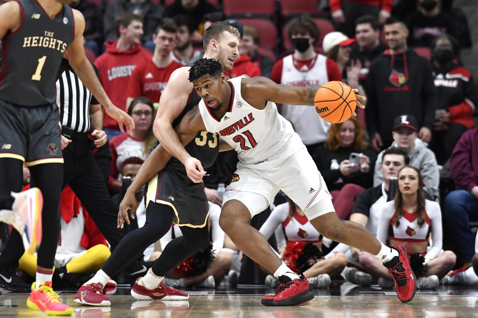 Louisville forward Sydney Curry (21) tries to fight his way past Boston College center James Karnik (33) during the first half of an NCAA college basketball game in Louisville, Ky., Wednesday, Jan. 19, 2022. (AP Photo/Timothy D. Easley)