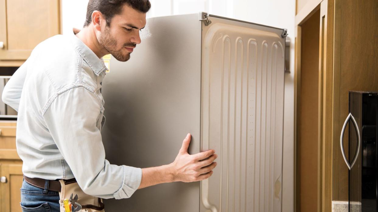  Man moving refrigerator. 